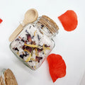 Lavvish Lavender and Rose Bath Salts in glass jar with wooden spoon and floral accents