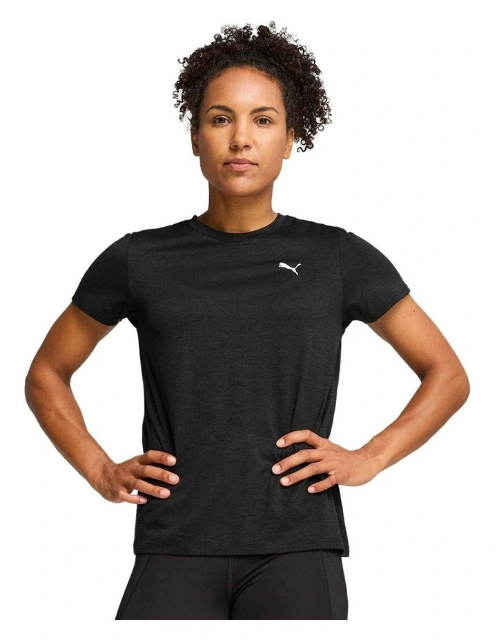 Woman in black athletic wear with a visible brand logo, posing against a white background