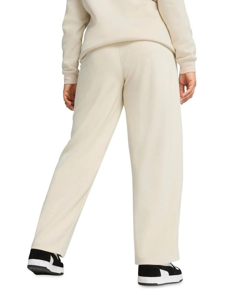 Person wearing a beige tracksuit with white sneakers on a white background