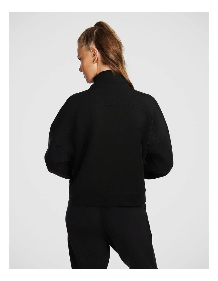 Rockwear Travel Zip Through in Black featuring cozy funnel neck and side pockets for stylish cold-weather wear.