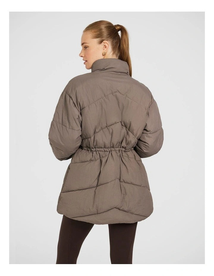 Rockwear Longline Puffer Jacket in Brown, women's full-length puffer jacket with side pockets, padded insulation, and elastic toggle waist for a flattering fit.