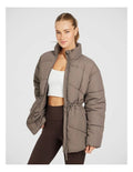Rockwear Longline Puffer Jacket in Brown, women's full-length puffer jacket with side pockets, padded insulation, and elastic toggle waist for a flattering fit.