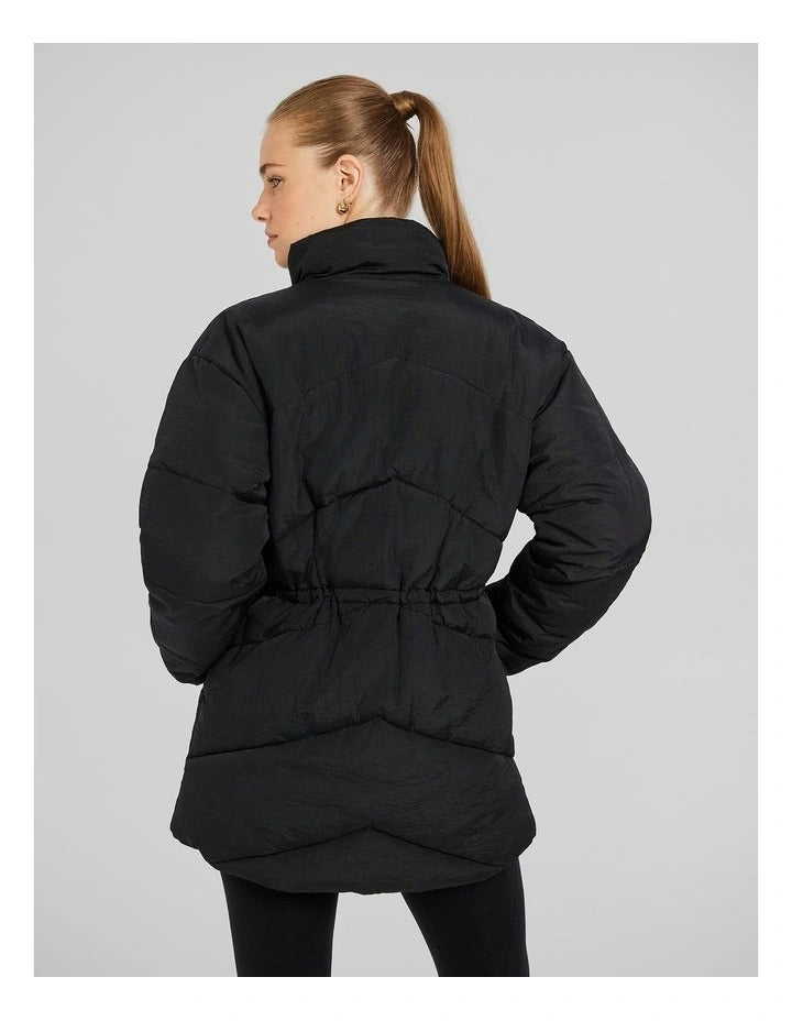 Rockwear Longline Puffer Jacket in Black, women's padded jacket with side phone pockets and a flattering cinched waist for warmth and style.