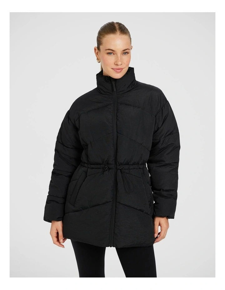 Rockwear Longline Puffer Jacket in Black, women's padded jacket with side phone pockets and a flattering cinched waist for warmth and style.