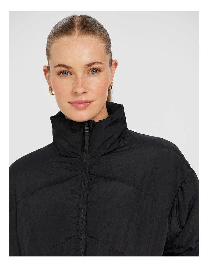 Rockwear Longline Puffer Jacket in Black, women's padded jacket with side phone pockets and a flattering cinched waist for warmth and style.