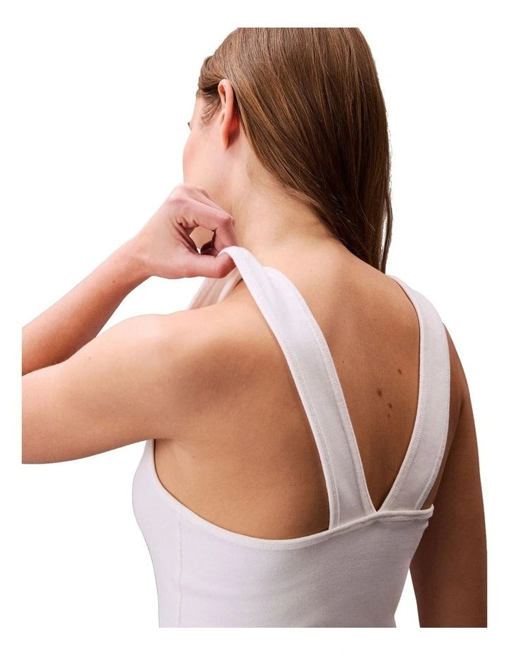 Calvin Klein Jeans white ribbed tank top with slim fit, scoop neck, sleeveless design and bold printed logo graphic at center