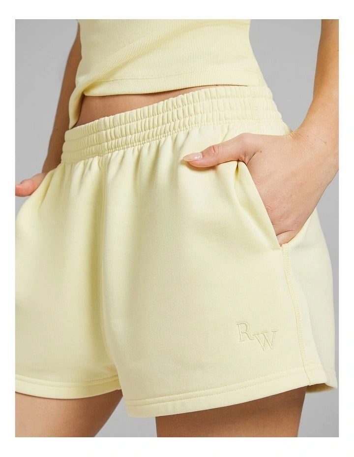 Rockwear women’s yellow cosy fleece shorts with relaxed fit, regular rise, and side phone pockets, perfect for lounging or casual wear.