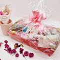 Lavvish Pamper Pack with wine bottle, skincare products, chocolates, and floral decorations in a festive gift box