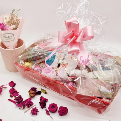 Lavvish Pamper Pack with wine bottle, skincare products, chocolates, and floral decorations in a festive gift box