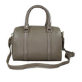 Beige genuine leather barrel shoulder bag with adjustable strap, minimalist design, and premium handcrafted finish.