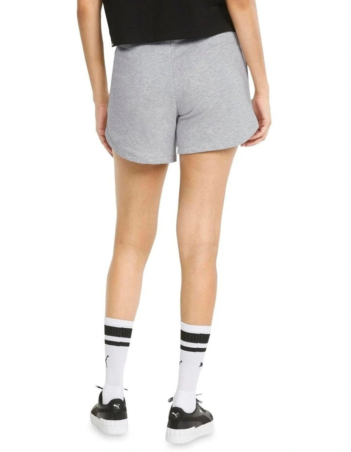 Person wearing gray Puma shorts on a white background