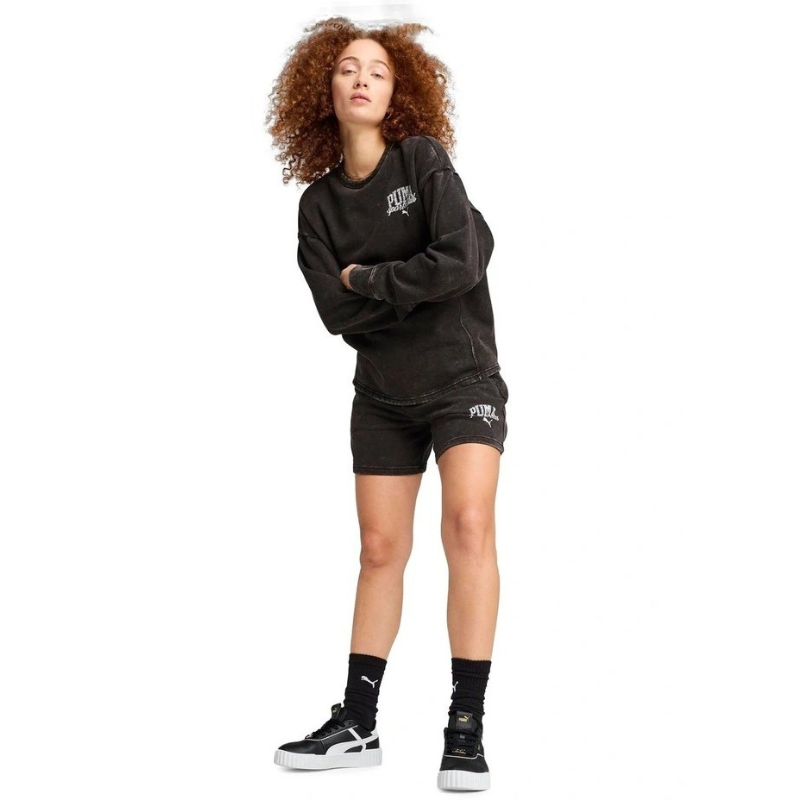 Person wearing a black hoodie and shorts set with visible branding on a white background
