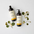 Two Sukin body care products with green leaves on a light background