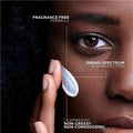 Person applying sunscreen with text highlighting features on a close-up of skin.