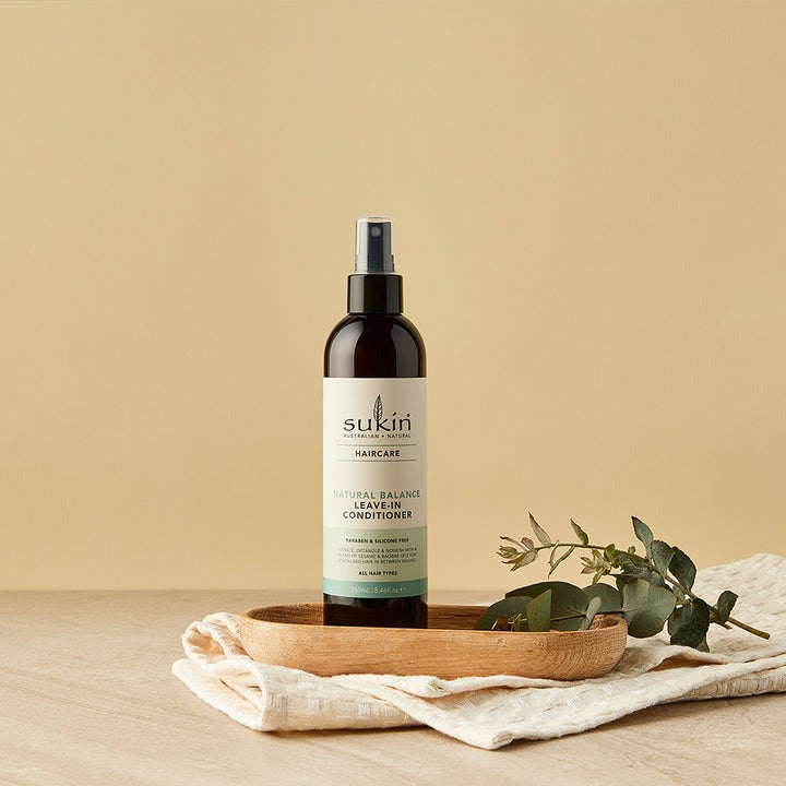 Sukin hair care product on a wooden tray with a beige background