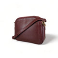 Red leather women’s shoulder bag with three compartments, elegant small satchel design featuring adjustable strap and gold hardware.