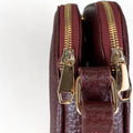Red leather women’s shoulder bag with three compartments, elegant small satchel design featuring adjustable strap and gold hardware.