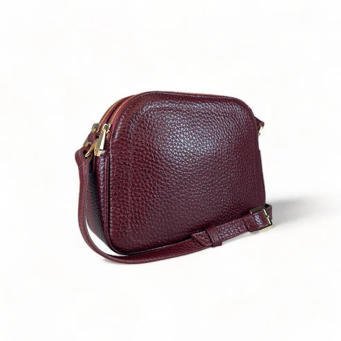 Red leather women’s shoulder bag with three compartments, elegant small satchel design featuring adjustable strap and gold hardware.