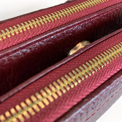 Red leather women’s shoulder bag with three compartments, elegant small satchel design featuring adjustable strap and gold hardware.