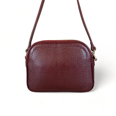 Red leather women’s shoulder bag with three compartments, elegant small satchel design featuring adjustable strap and gold hardware.