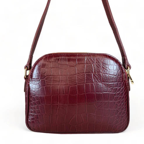 Dark red crocodile-embossed leather shoulder bag with gold hardware and adjustable crossbody strap, luxury women’s handbag on white background.