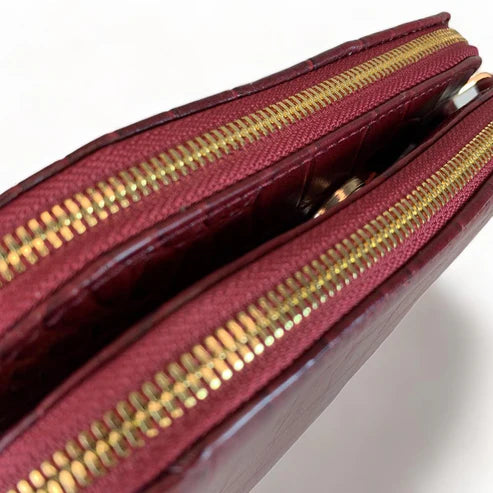 Dark red crocodile-embossed leather shoulder bag with gold hardware and adjustable crossbody strap, luxury women’s handbag on white background.