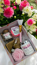Lavvish Relax self-care gift box with skincare products, bath salts, donut soap, face mask brush, and rose decor displayed on tropical background