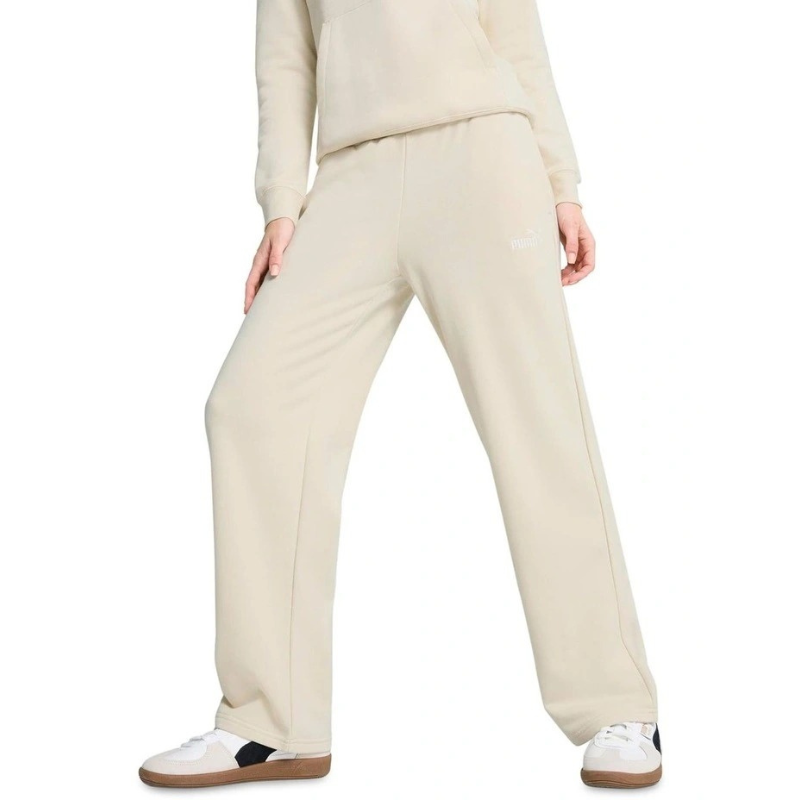 Person wearing a beige tracksuit with white sneakers on a white background