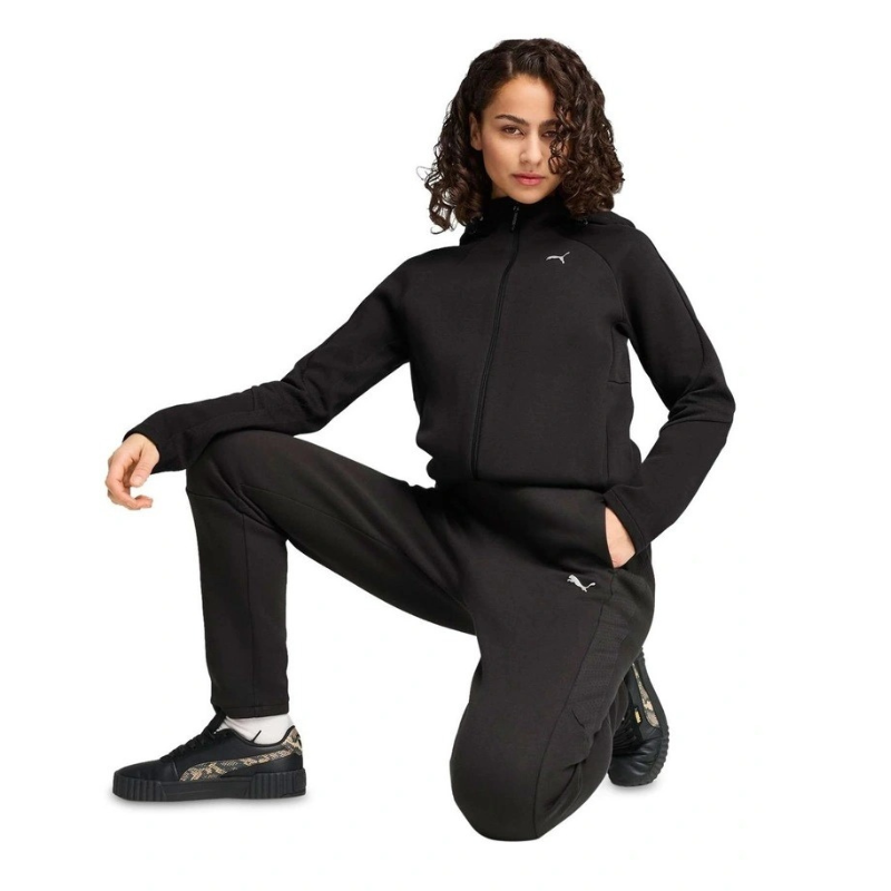 Person wearing a black Puma tracksuit on a white background