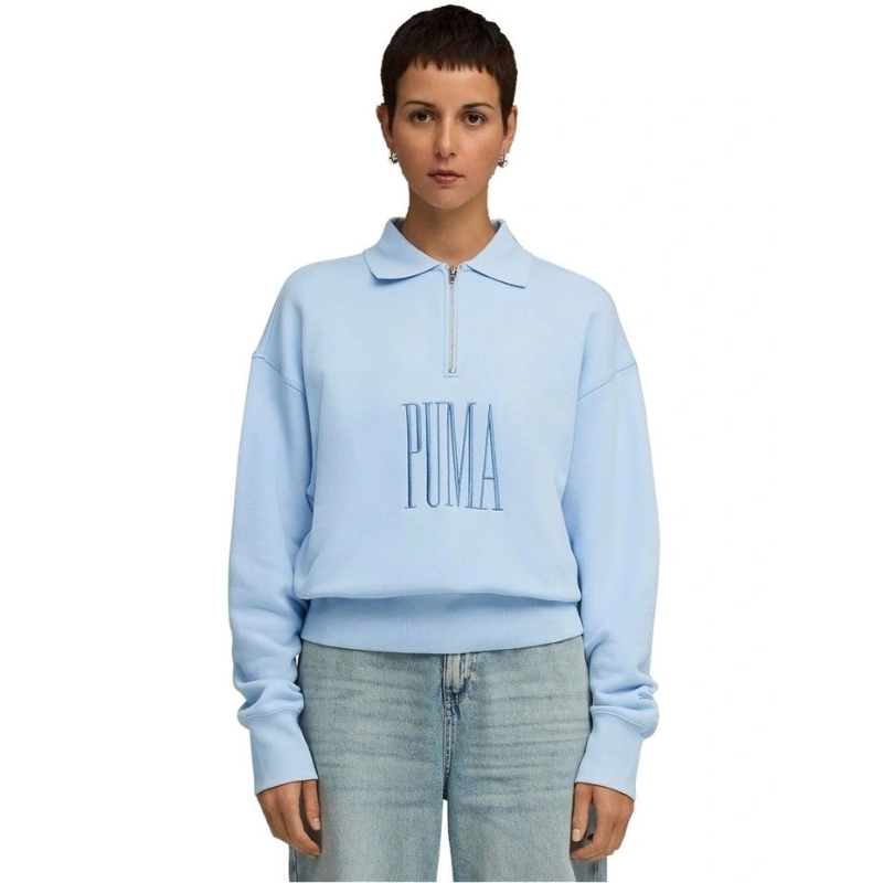 Person wearing a light blue Puma sweatshirt on a white background