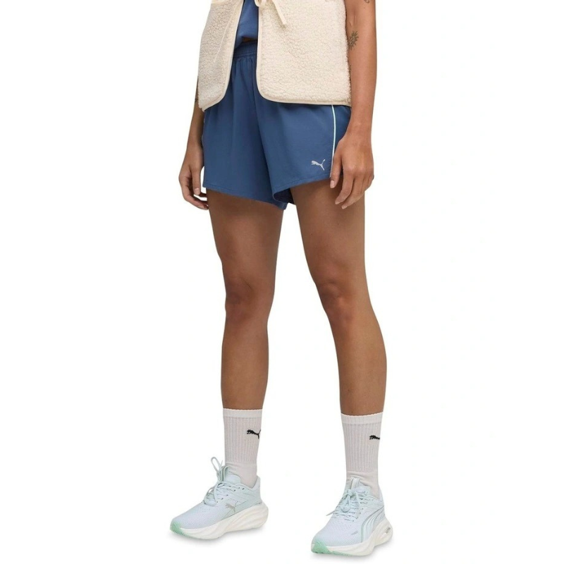 Person wearing blue athletic shorts with a visible brand logo on a white background