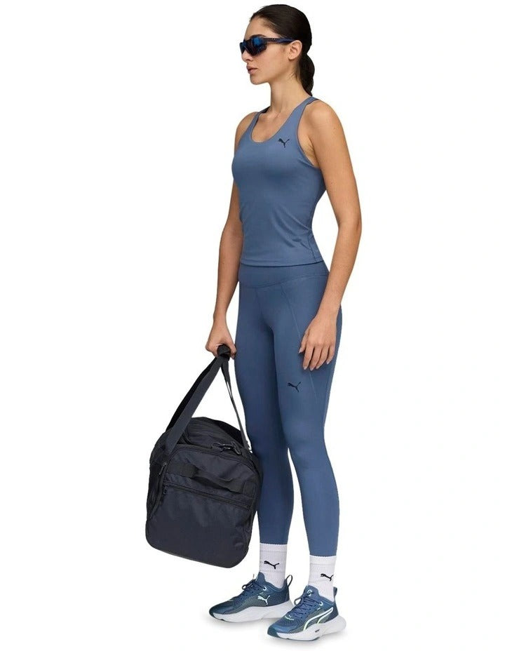 Woman wearing a blue athletic outfit with a Puma logo on a white background