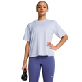 Woman wearing a light blue athletic shirt and purple leggings holding a black kettlebell on a white background