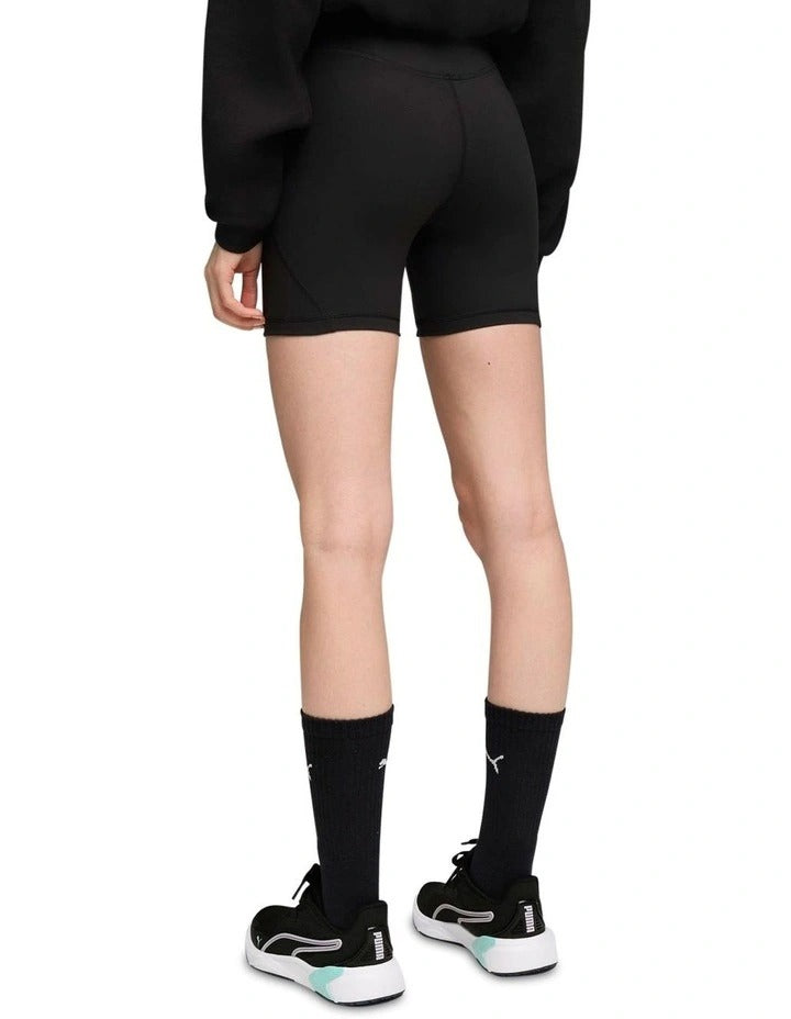 Person wearing black athletic shorts and socks on a white background
