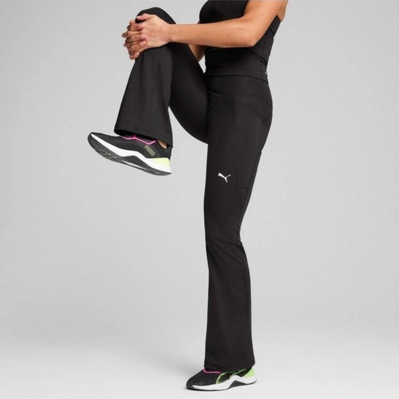 Person wearing black athletic pants with a visible brand logo on a gray background