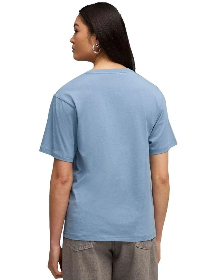Woman wearing a blue t-shirt with a brand logo on a white background