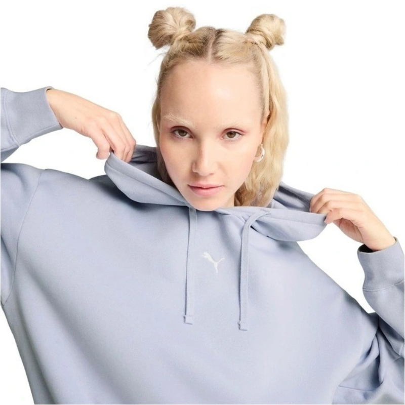 Person wearing a light blue hoodie with a brand logo, standing against a plain background