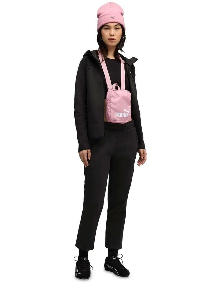 Person wearing a black tracksuit and pink beanie with Puma logo on a white background