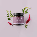 Sukin skincare jar with pink flowers and green leaves on a light purple background