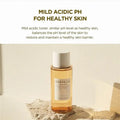 Skincare bottle with text about mild acidic pH for healthy skin on a beige background
