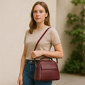 Elegant dark red genuine leather women’s satchel handbag with structured medium design and gold-tone accents — perfect for everyday and office wear.