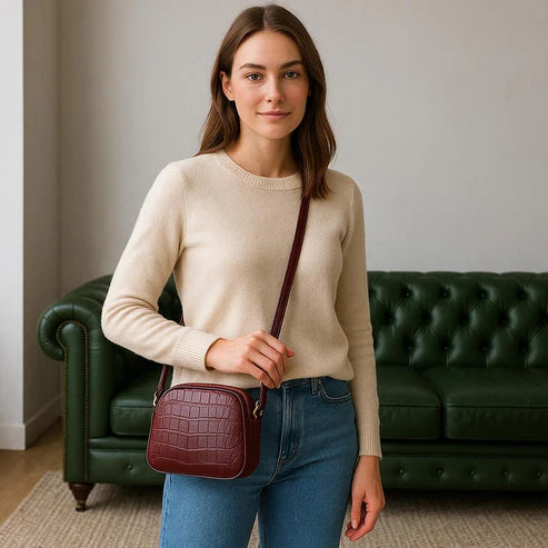 Dark red crocodile-embossed leather shoulder bag with gold hardware and adjustable crossbody strap, luxury women’s handbag on white background.