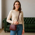 Dark red crocodile-embossed leather shoulder bag with gold hardware and adjustable crossbody strap, luxury women’s handbag on white background.