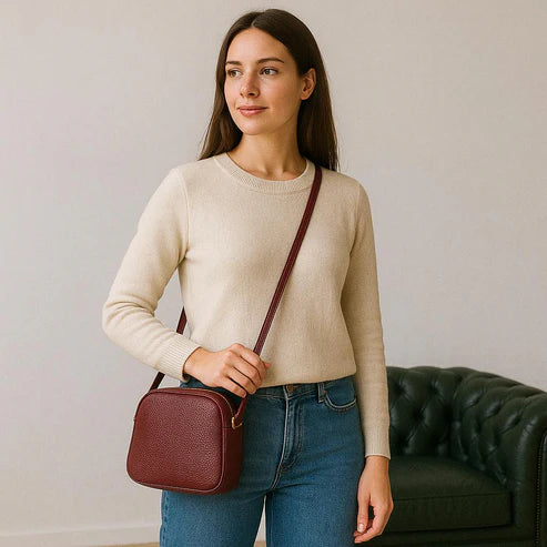 Red leather women’s shoulder bag with three compartments, elegant small satchel design featuring adjustable strap and gold hardware.