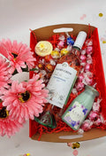 Purple Lavvish self-care gift box with skincare products, bath salts, soap bar, facial roller, and bath bomb displayed on purple floral background