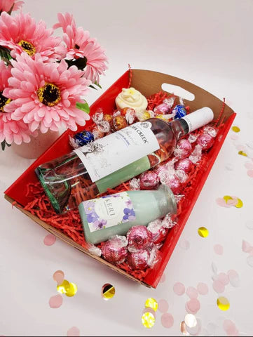 Purple Lavvish self-care gift box with skincare products, bath salts, soap bar, facial roller, and bath bomb displayed on purple floral background