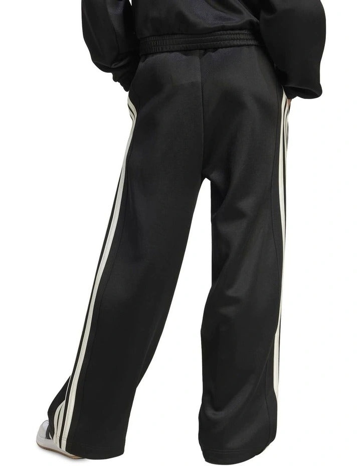 Adidas Stadium Stripes Tracksuit Bottoms in black with signature 3-Stripes, soft recycled polyester-cotton blend, satin piping, and matte rubber-print logo.