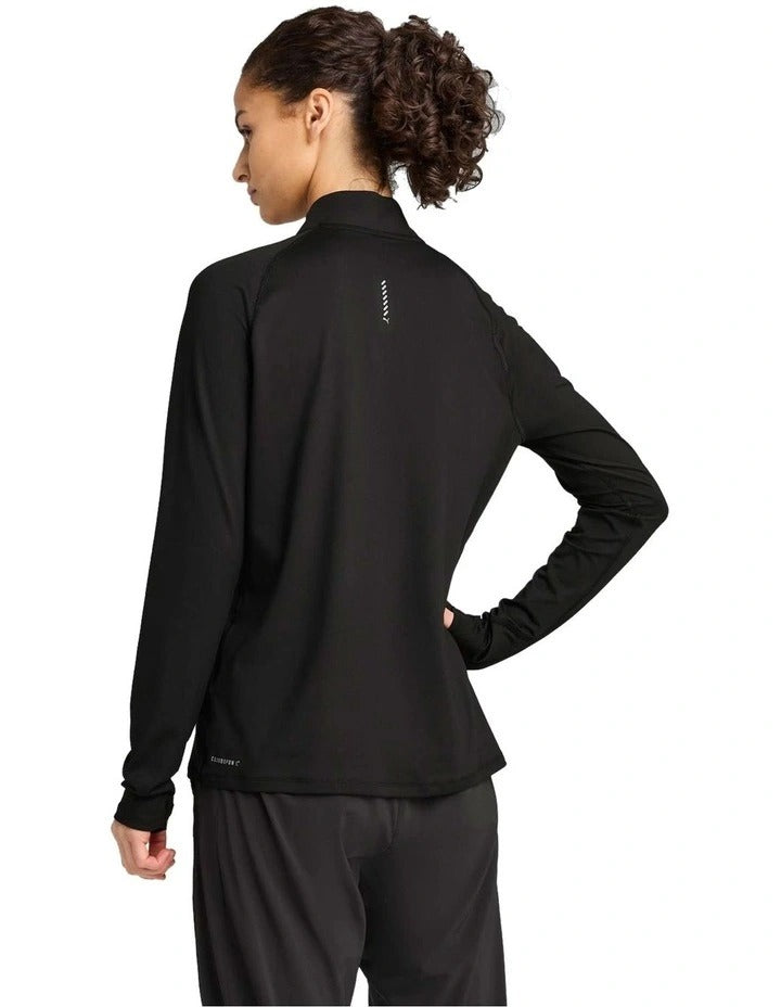Person wearing a black long-sleeve athletic top with a brand logo on a white background