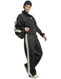 Adidas Stadium Stripes Tracksuit Bottoms in black with signature 3-Stripes, soft recycled polyester-cotton blend, satin piping, and matte rubber-print logo.