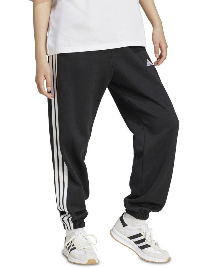 Adidas Essentials 3-Stripes Fleece Loose-Fit Joggers in grey, cozy casual pants with iconic side stripes, made from recycled cotton and polyester blend